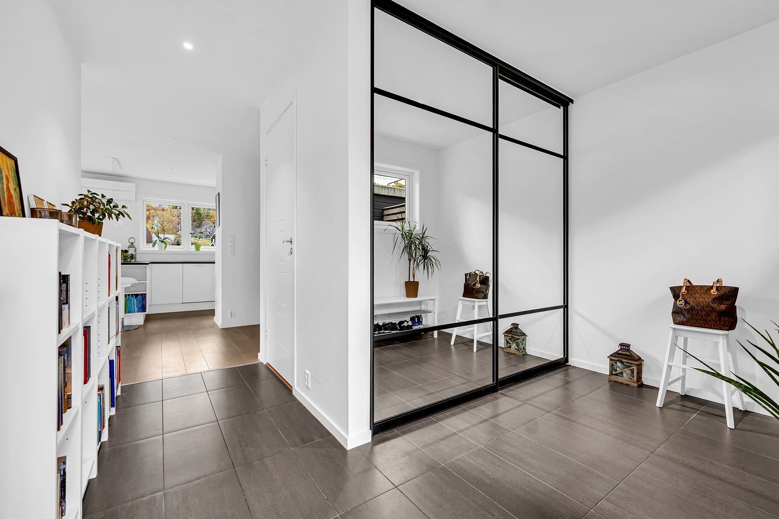 Innbydende entré med et elegant garderobeskap med speildører, som gir god plass til å henge fra seg yttertøy og oppbevare sko. Galleribilde