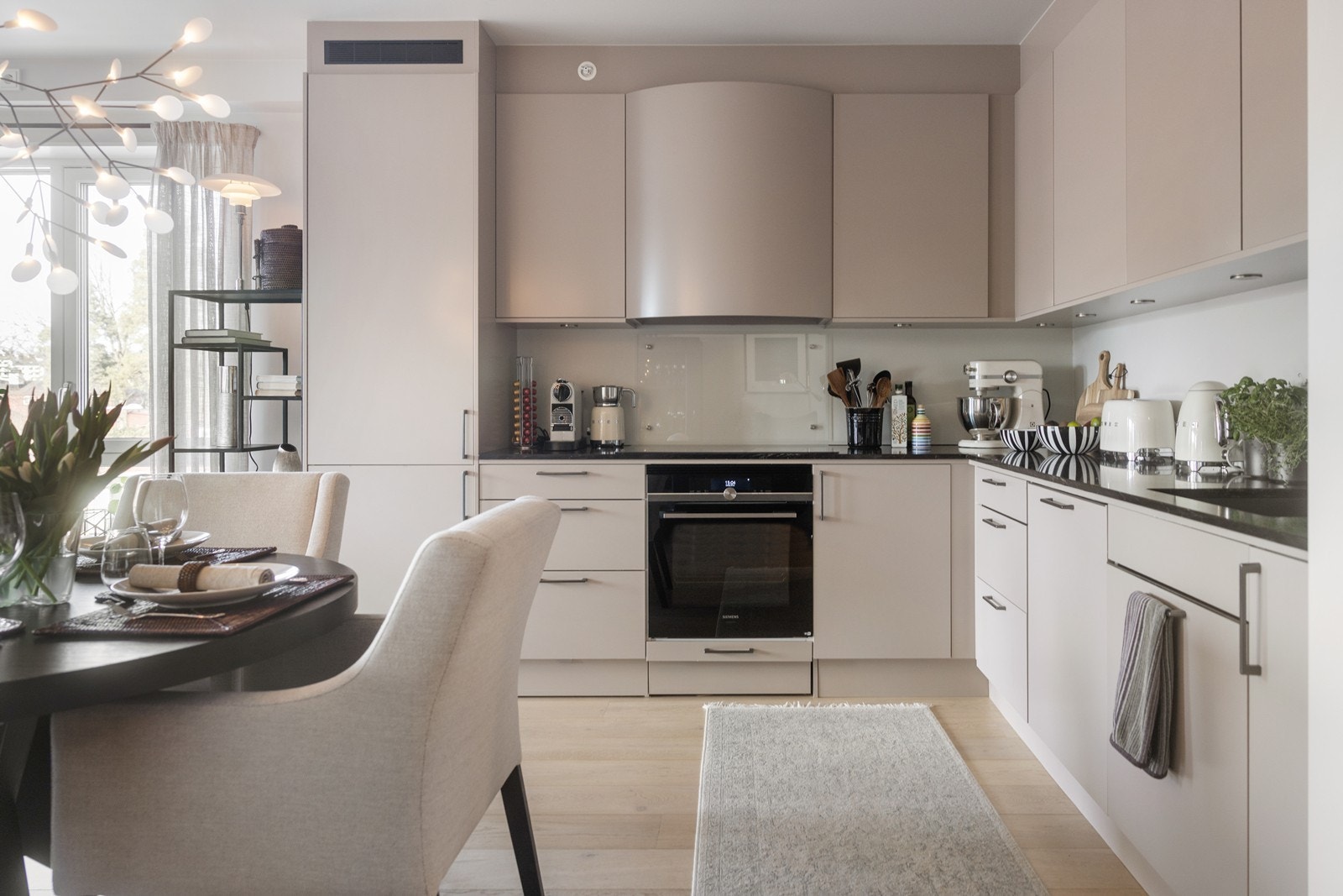 Lekkert kjøkken i fargen "østers beige". Benkeplate i stein og integrerte hvitevarer. Galleribilde