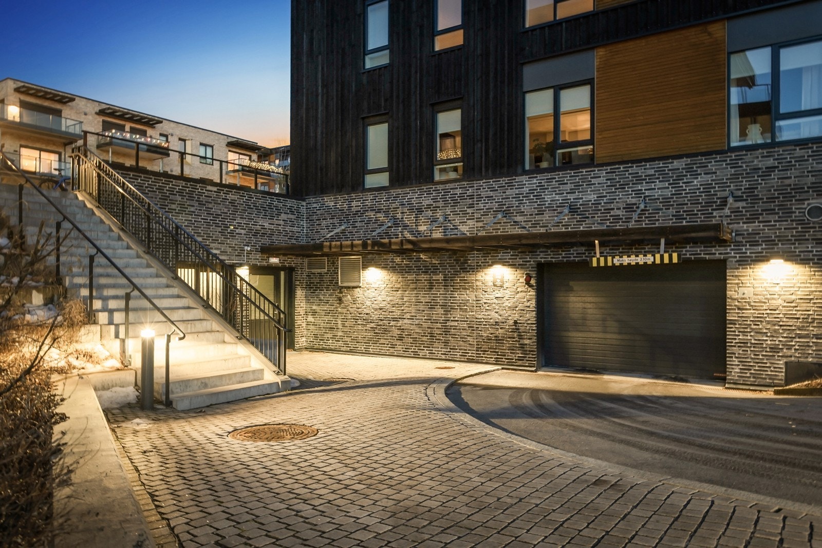 Innkjørsel til garasje. Døren ved siden av trappen fører til sykkelparkering med sykkelvask. Galleribilde