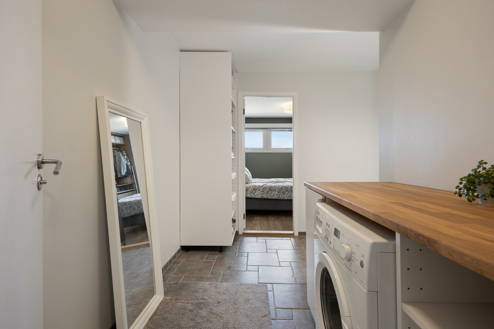 En praktisk vaskeromsdel med god benkeplass over vaskemaskinen. Galleribilde