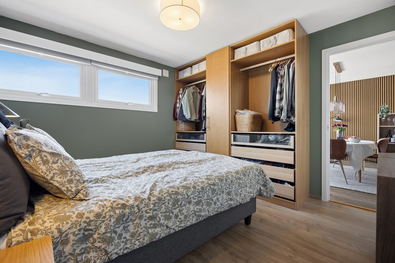 Fra badet er det direkte tilkomst til et av boligens romslige soverom - en løsning som både er praktisk og tidseffektiv. Dette soverommet er romslig og tilgjengelig både fra entréen via badet og videre inn mot kjøkkenets spisestue. Galleribilde