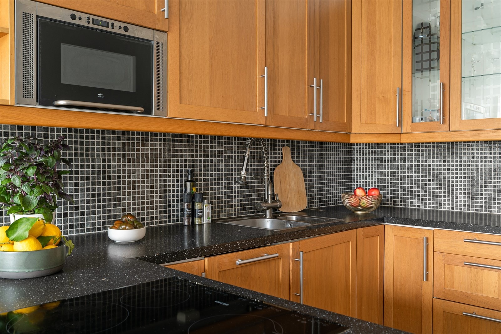 Kjøkkenet består av finerte fronter og mørk laminat benkeplate. Av medfølgende hvitevarer har du integrert mikro, oppvaskmaskin, steketopp, komfyr og kombi kjøl/frys. Galleribilde