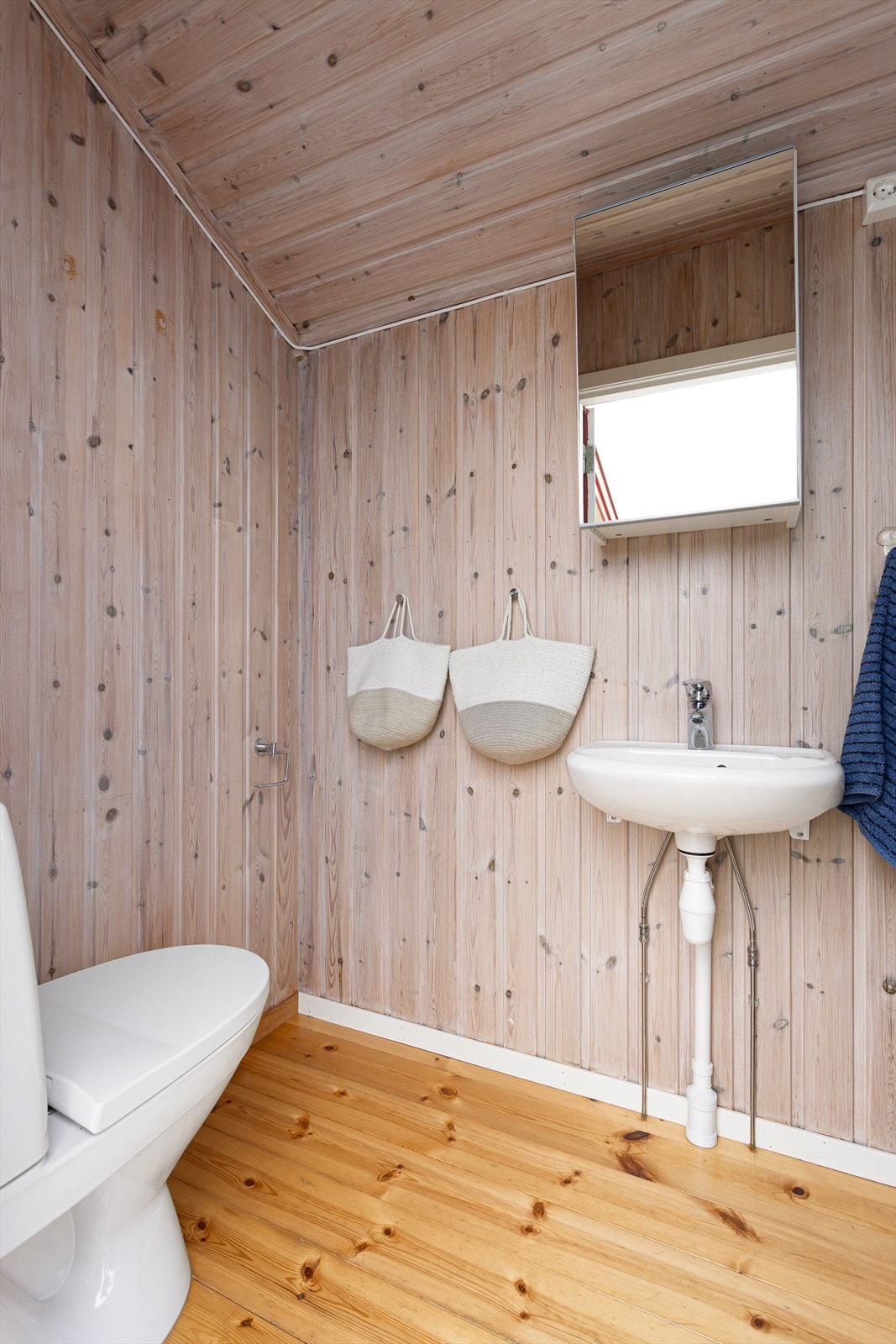 Badet inneholder toalett, servant med speilskap og dusjkabinett. Galleribilde