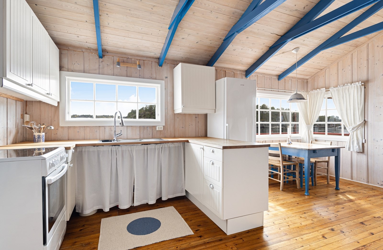 Kjøkkenet inneholder heltre benkeplate og lysmalte skapfronter. Galleribilde