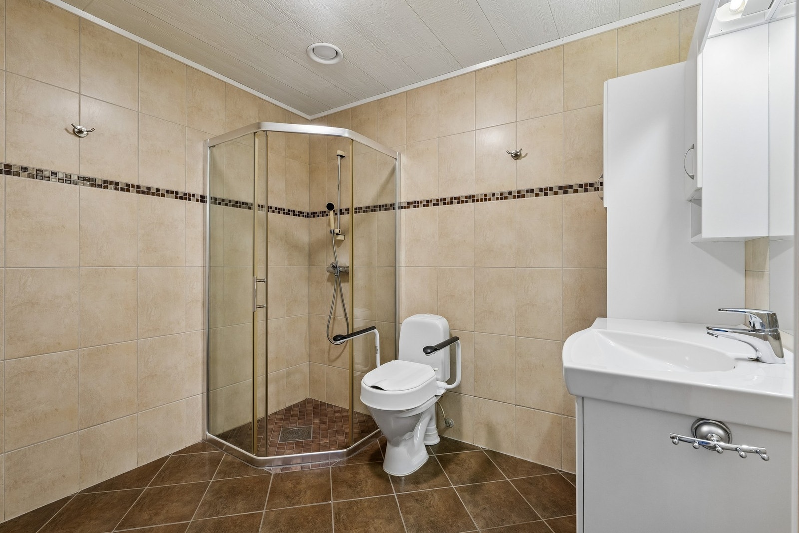 Flislagt bad med gulvvarme og praktisk baderomsinnredning. Galleribilde