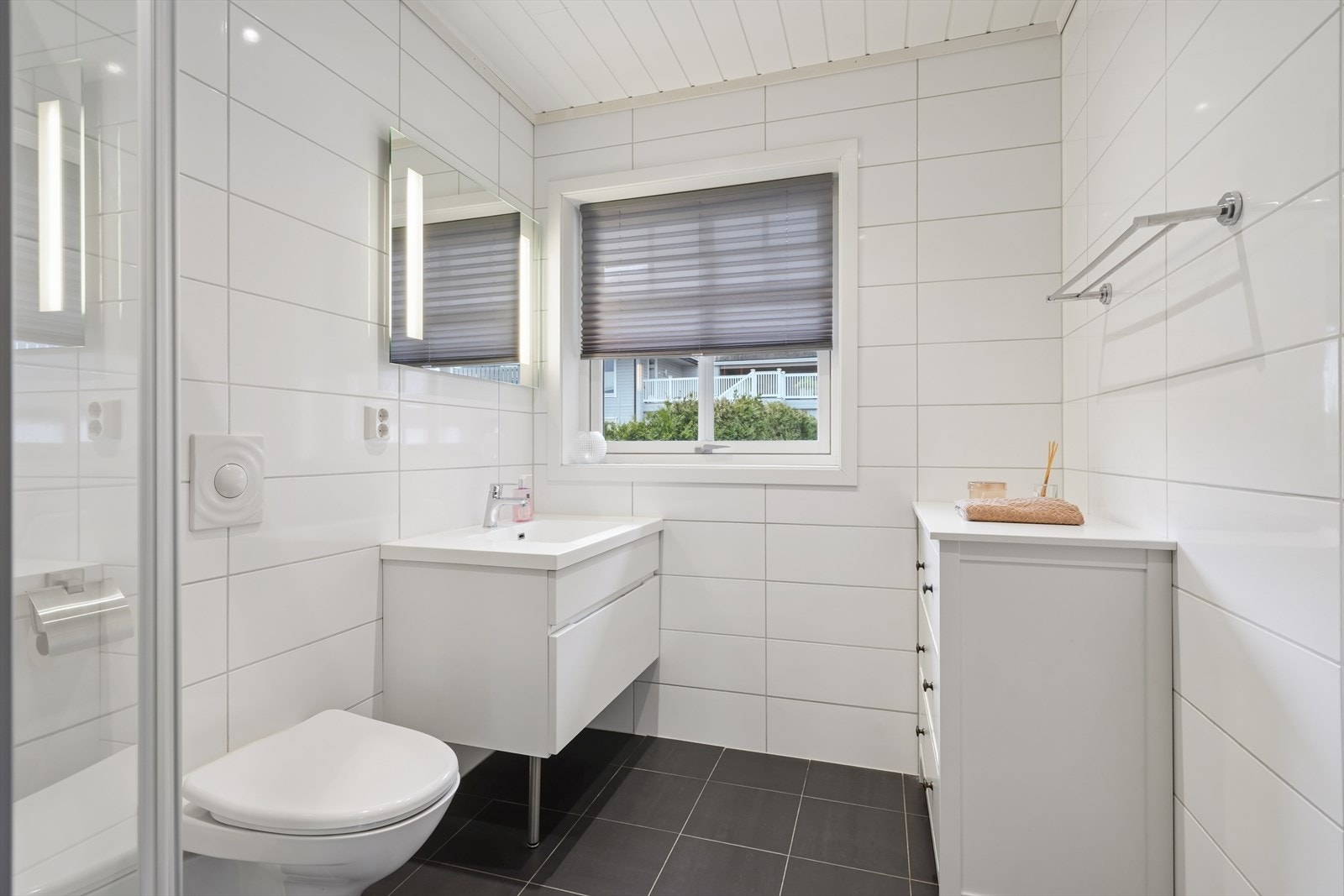 Badet i andre etasje er helfliset og utstyrt med vegghengt toalett, dusjhjørne og servant med underskap. Galleribilde