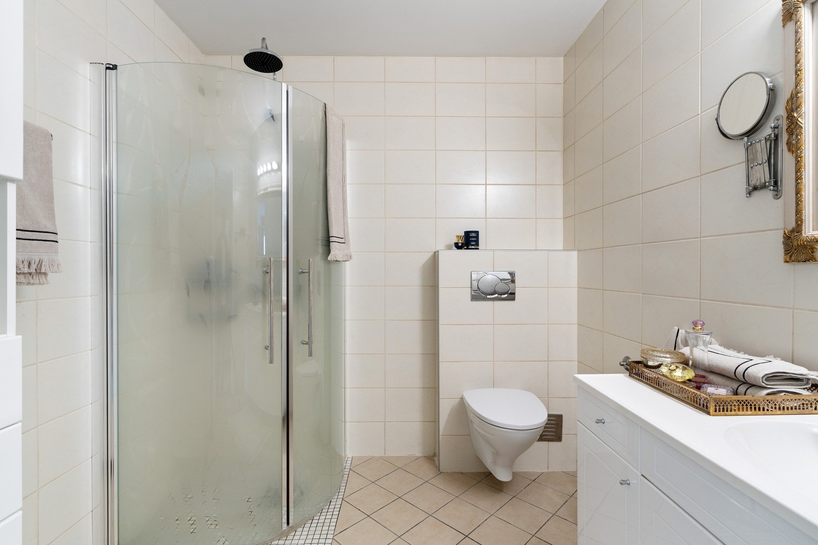 Innfellbare dusjdører, regndusj og vegghengt toalett. Galleribilde