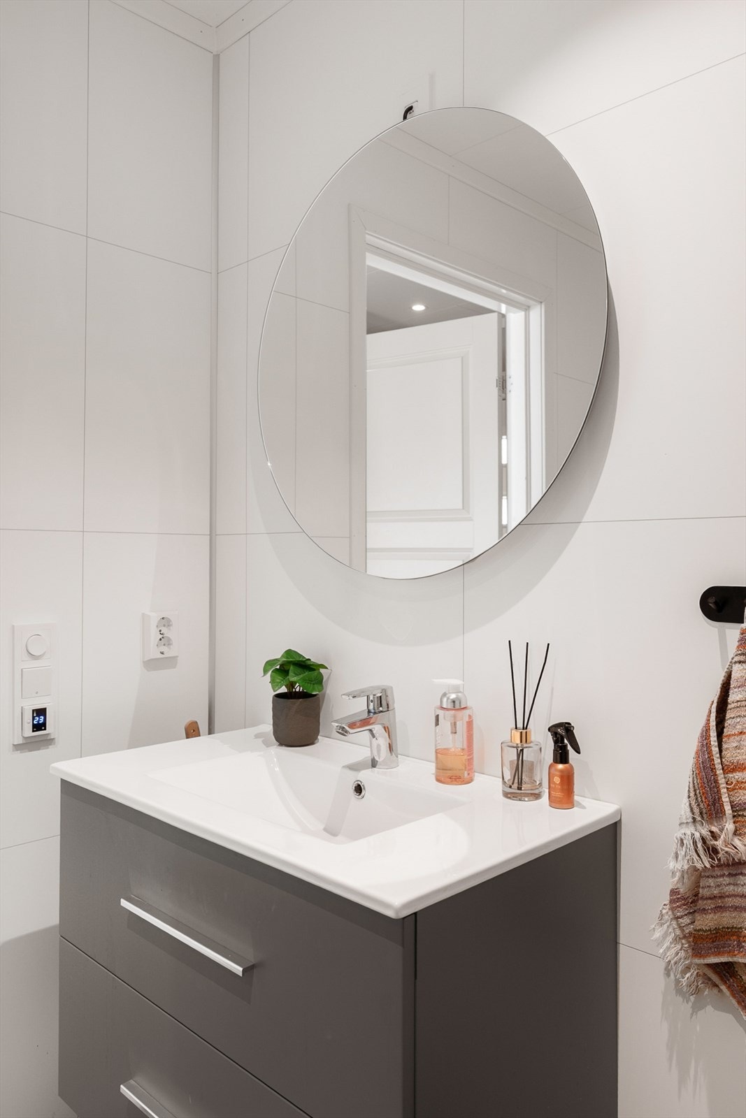 Badet har servant med underskap, speil med belysning, dusjvegger, vegghengt toalett og opplegg for vaskemaskin. Galleribilde