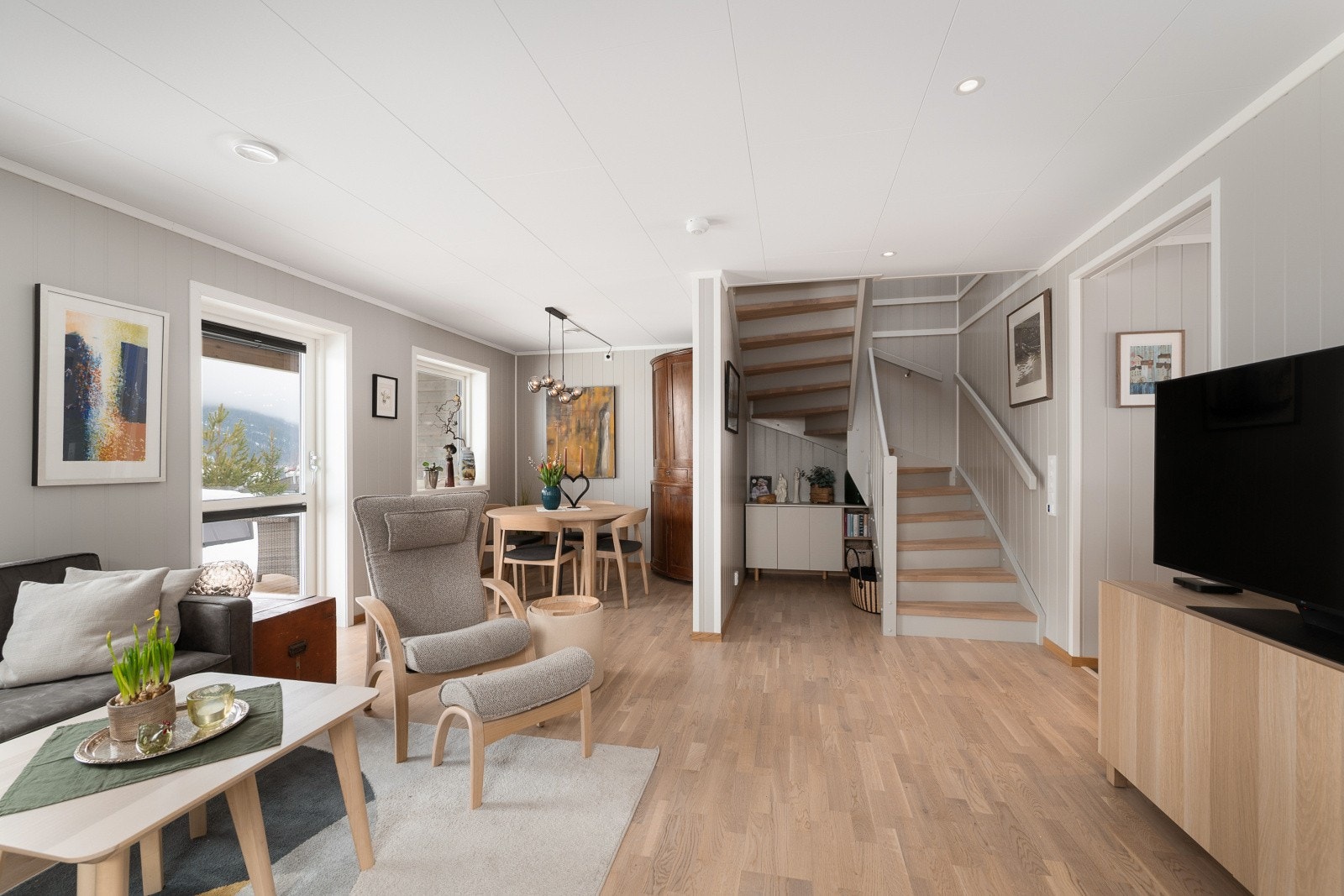 Den åpne løsningen gir en god romfølelse og en naturlig overgang mellom sonene og trappen til andre etasje. Galleribilde