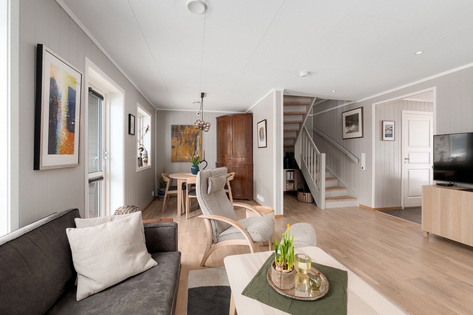 Gjennomgående materialvalg som parkett og panelplater skaper en helhetlig stil i første etasje. Galleribilde