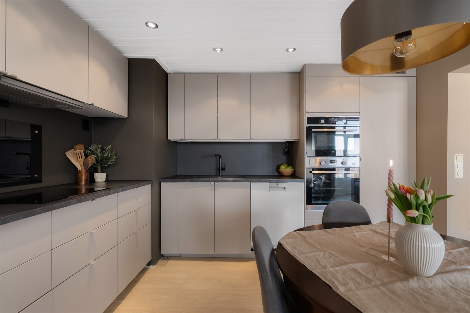 Innredningen har glatte fronter og integrerte hvitevarer som komfyr, kombiovn og kjøleskap. Galleribilde