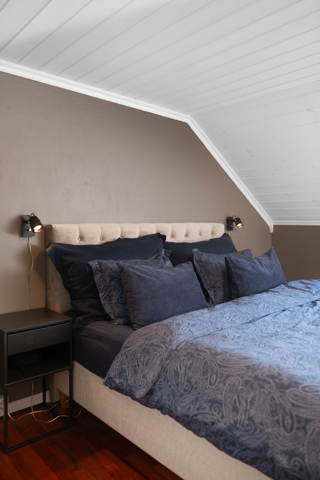 De sjarmerende skråtakene med malt panel fortsetter inn på soverommene. Galleribilde