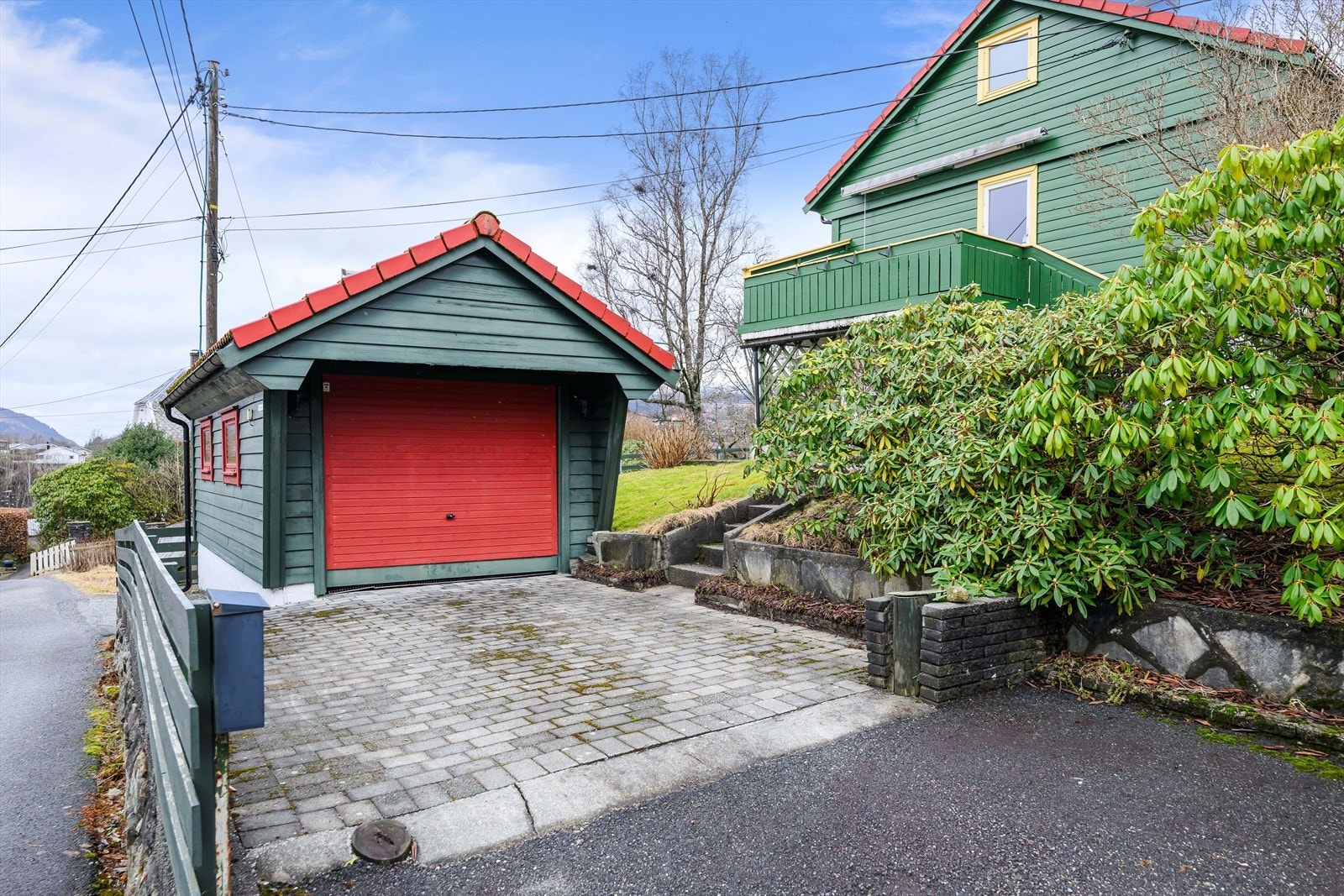 Frittliggende enkelgarasje og biloppstillingsplass på tomten. Galleribilde