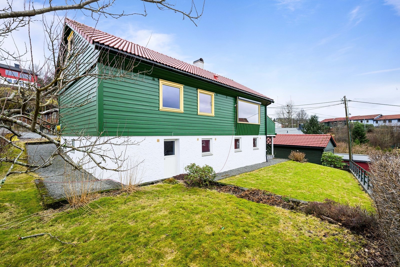 Boligen er opparbeidet med plen og har grus/pukk inntil mur. Biinngang til kjelleretasje. Galleribilde