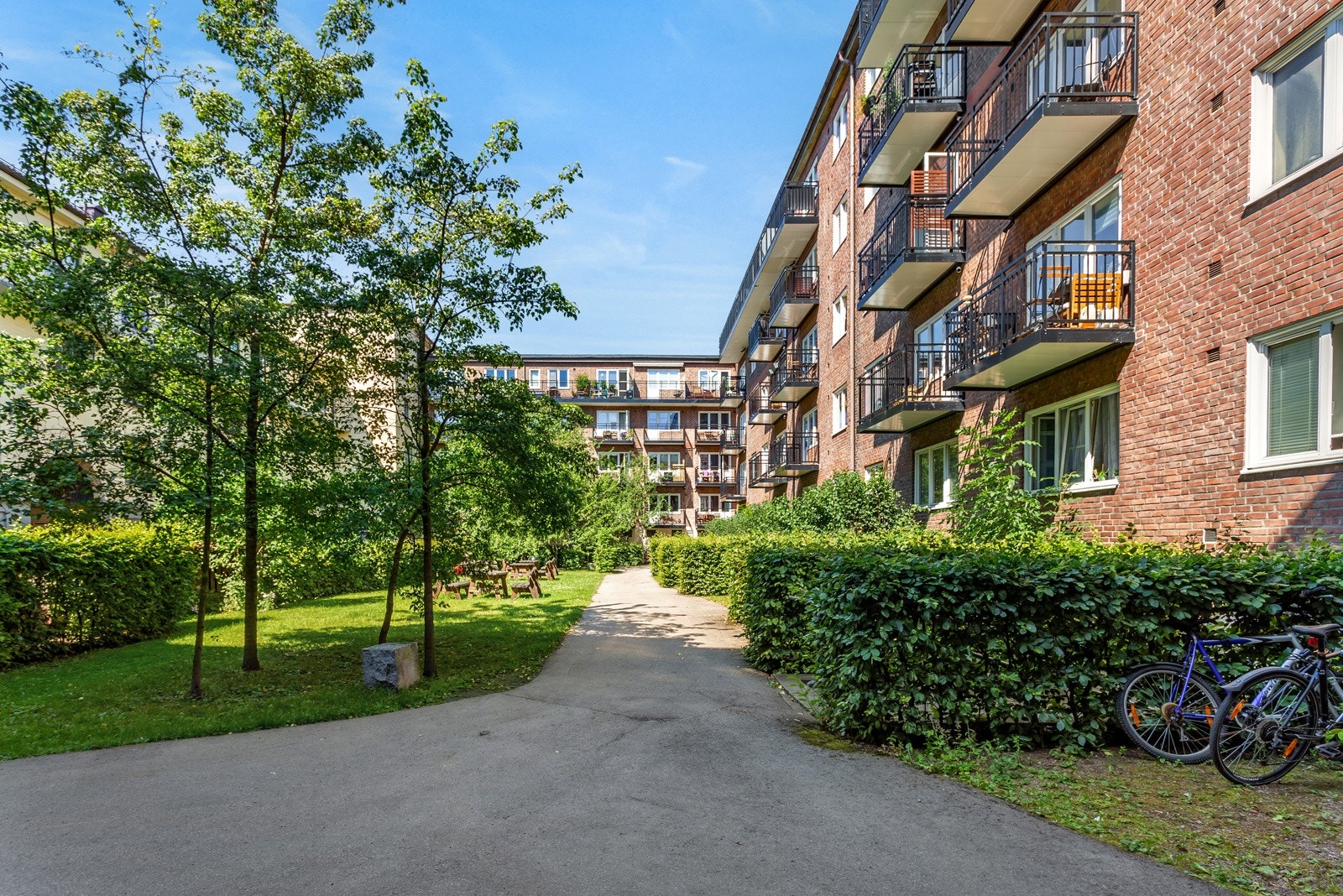 Rett ut fra stue/kjøkkenvindu finner du en flott opparbeidet bakgård med grøntarealer og sitteplasser. Galleribilde