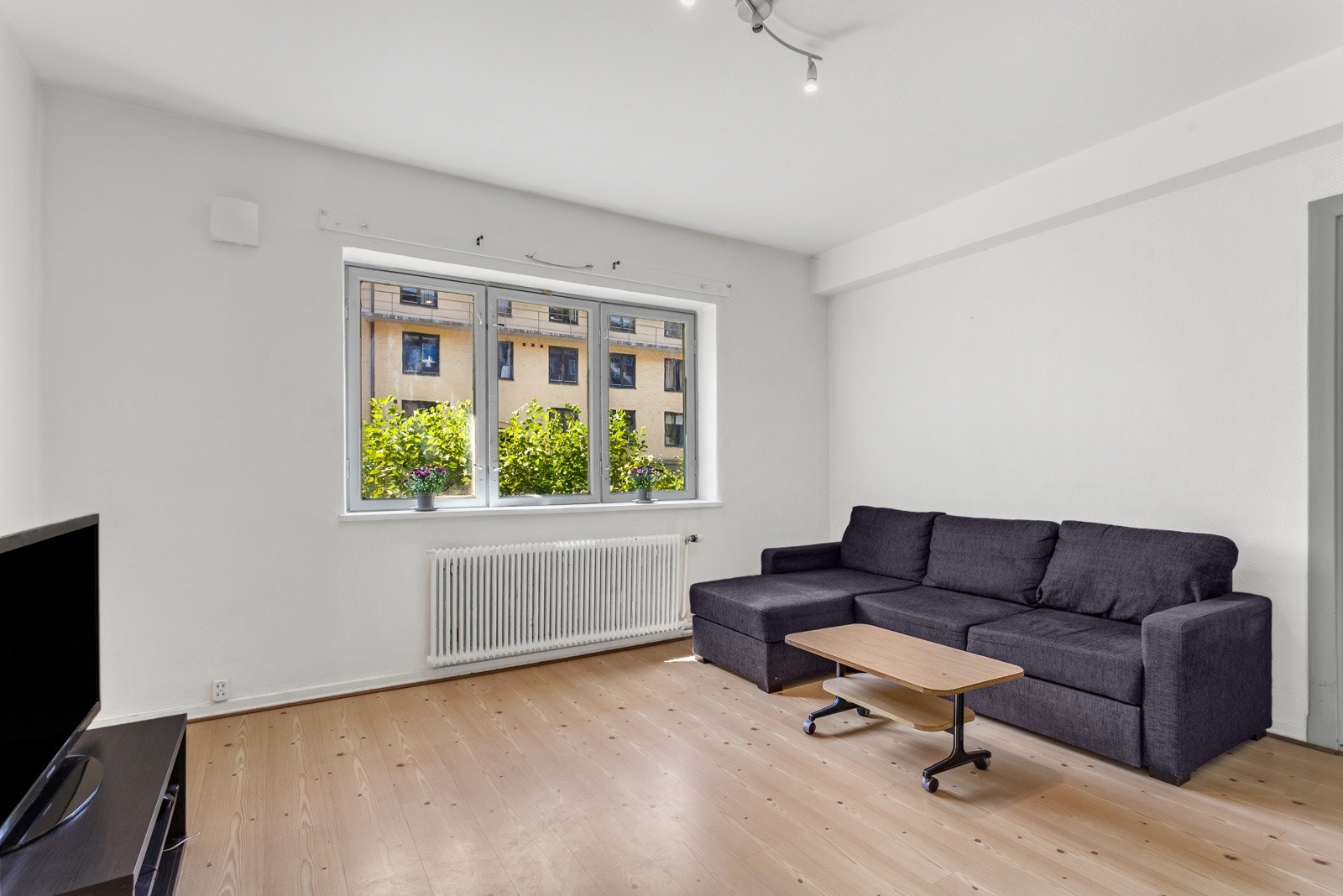 Leiligheten har en romslig stue med vindu som vender ut mot en stille og frodig bakgård. Galleribilde