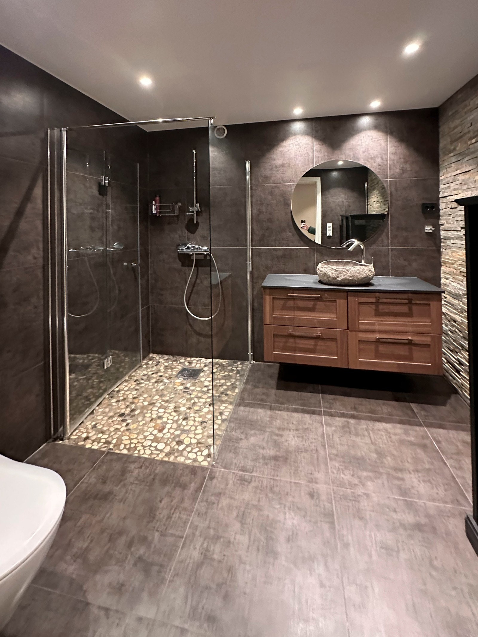 Privat bilde. Dusjbadet ble helrenovert i 2018 med bl.a. en dekorert skifersteinvegg som bryter opp og gir karakter. Galleribilde