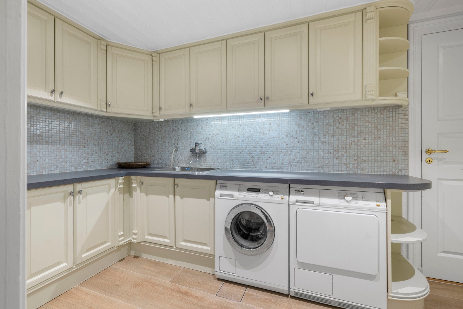 Vaskerommet fikk en oppgradering i 2023 med rikelig skap- og benkeplass som gjør det enkelt å holde hjemmet ryddig og organisert. Galleribilde