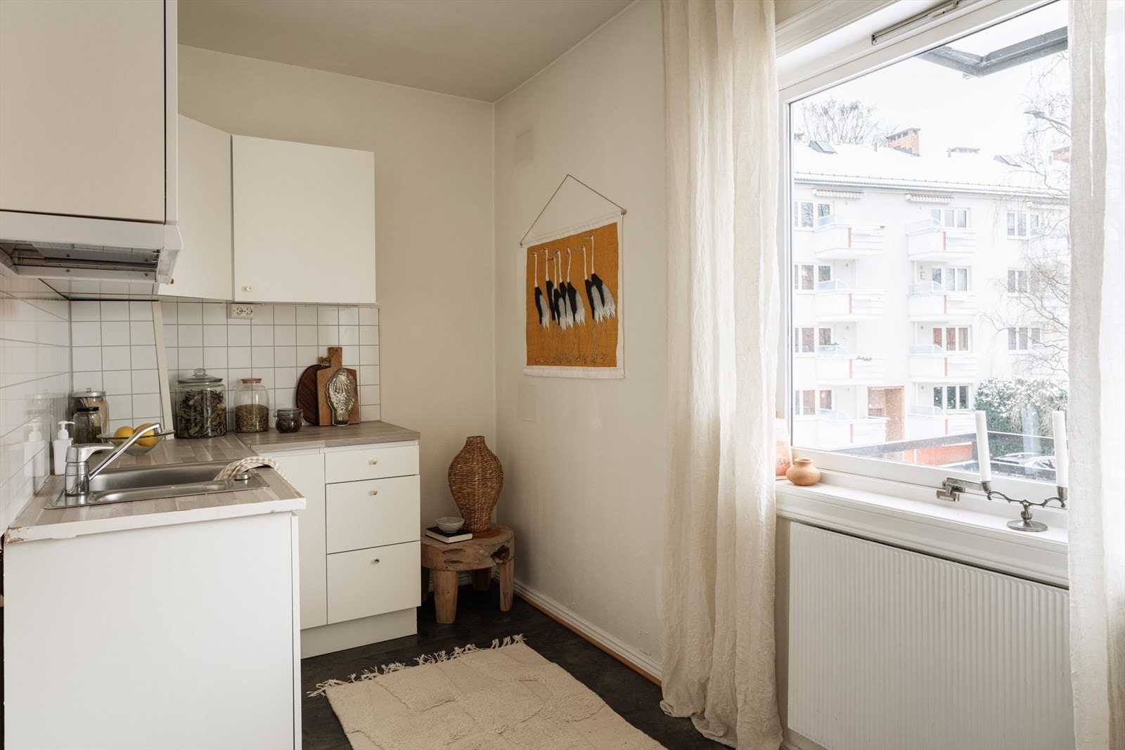 Innredningen består av nøytrale, hvite fronter, fliser på bakvegg, laminert benkeplate og det er plass til frittstående hvitevarer. Galleribilde