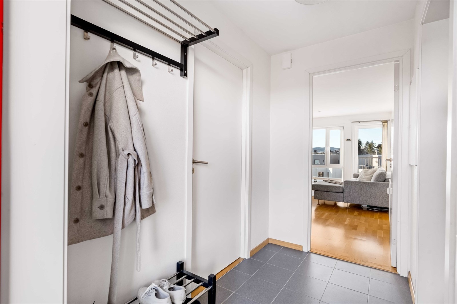 Boligen har en lys og innbydende entré, med god plass til å henge fra seg ytterøy. Det er praktiske fliser på gulvet. Galleribilde