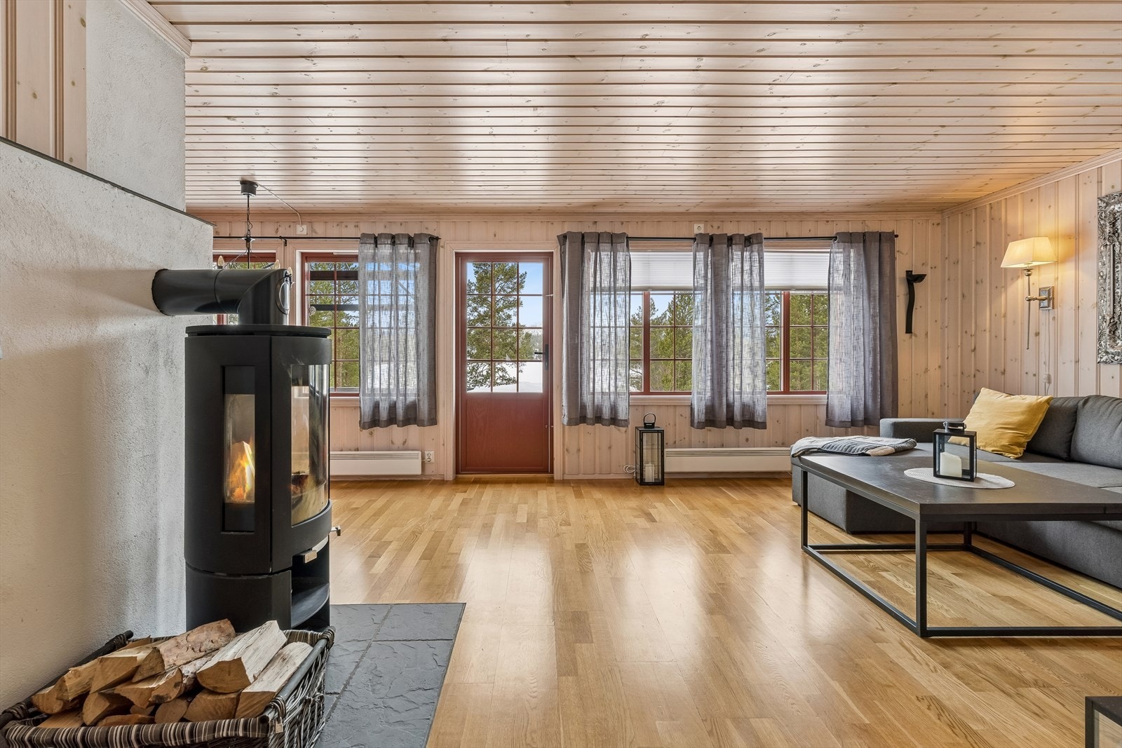 En sentralt plassert vedovn. Store vindusflater gir godt med lys inn. Galleribilde