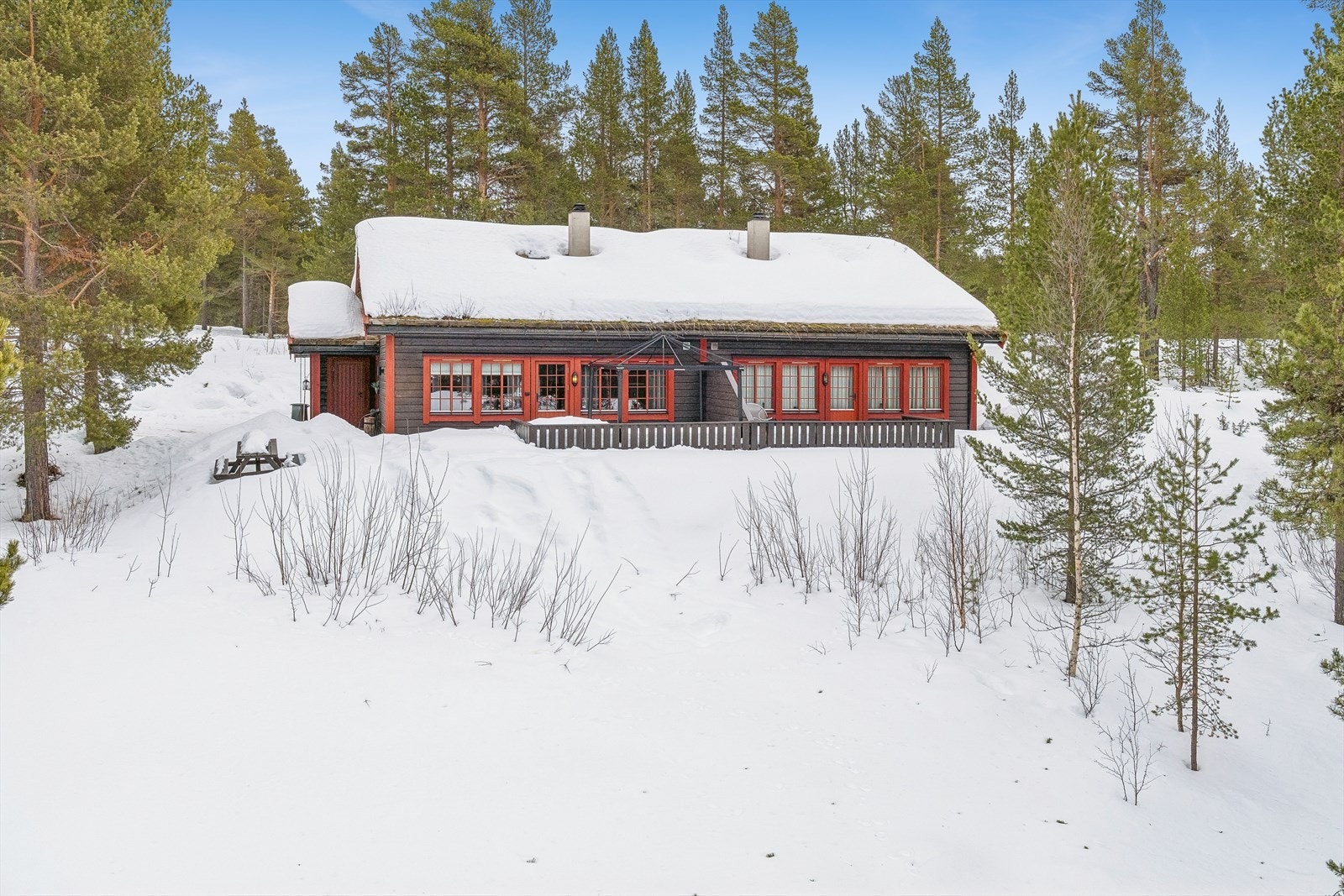 En klassisk fritidsbolig fra 2006 med torvtak og liggende kledning. Enheten som selges er til venstre i bildet. Galleribilde