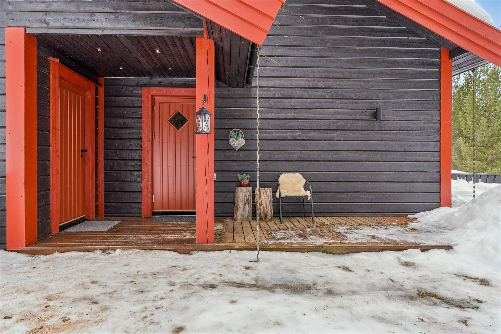 Overbygget inngangsparti med en terrasseplatting ved hoveddøren. Galleribilde