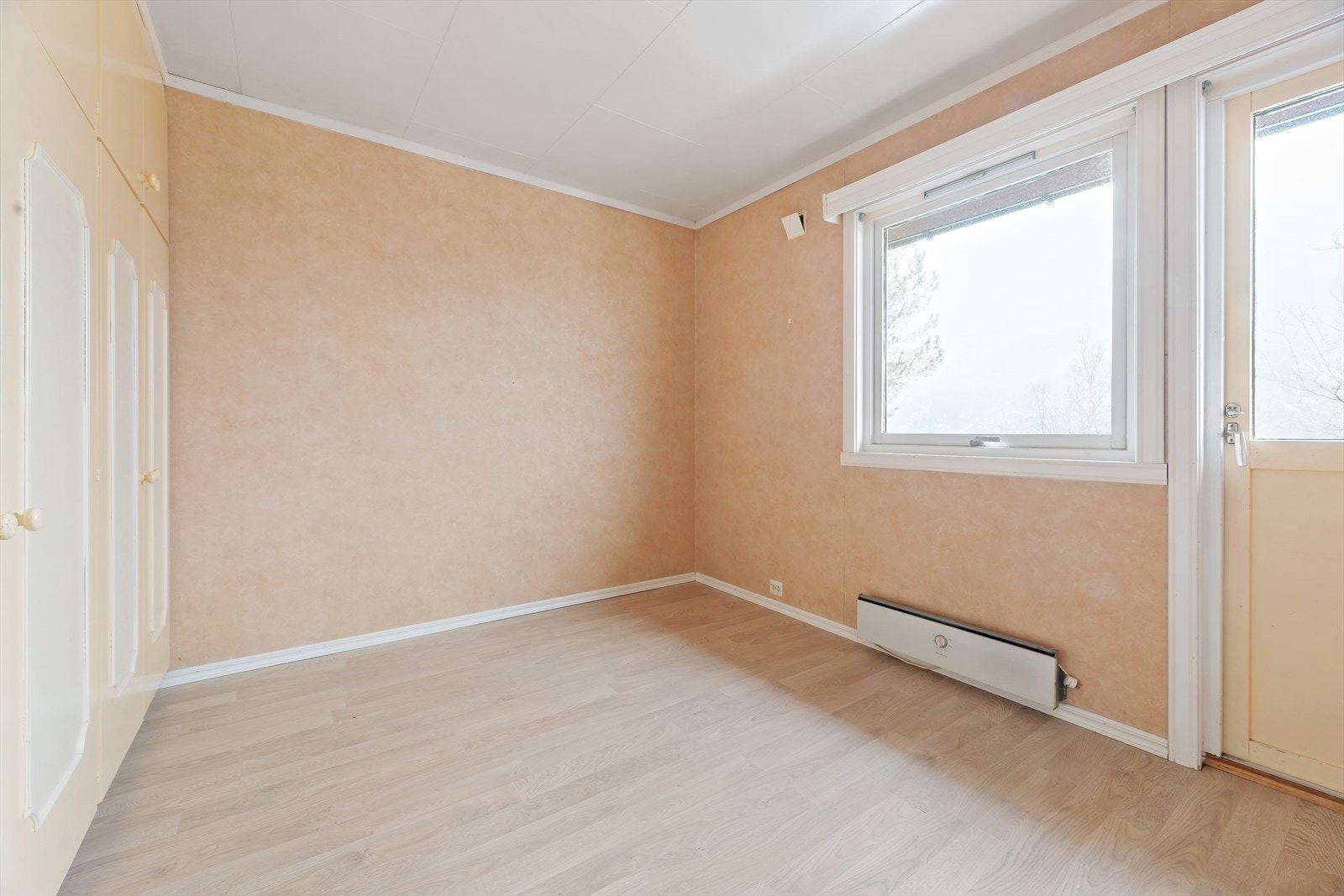 Hovedsoverom i hovedplan. Plassbygde garderobeskap. Dør ut til veranda. Galleribilde