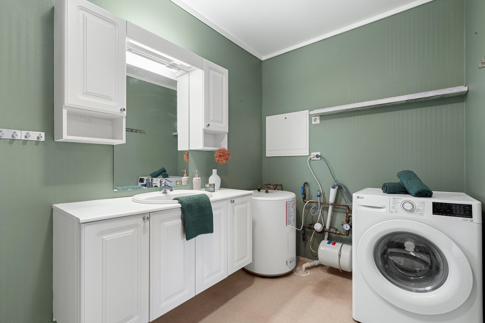 Badet er utstyrt med vask i servant, dusjhjørne, toalett, varmtvannbereder og opplegg til vask- og tørk. Galleribilde