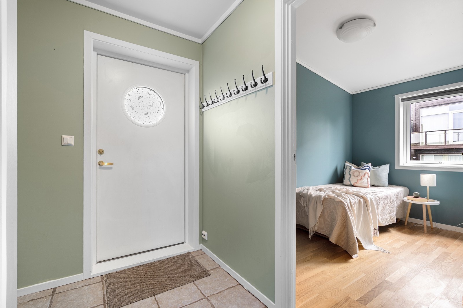 Entréen har flislagt gulv og malte vegger. Galleribilde