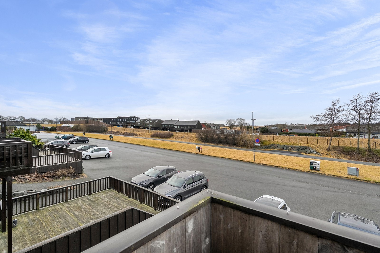 Utsikt fra balkongen mot grøntområde og parkeringsplass. Til leiligheten følger det med 2 parkeringplasser. Galleribilde