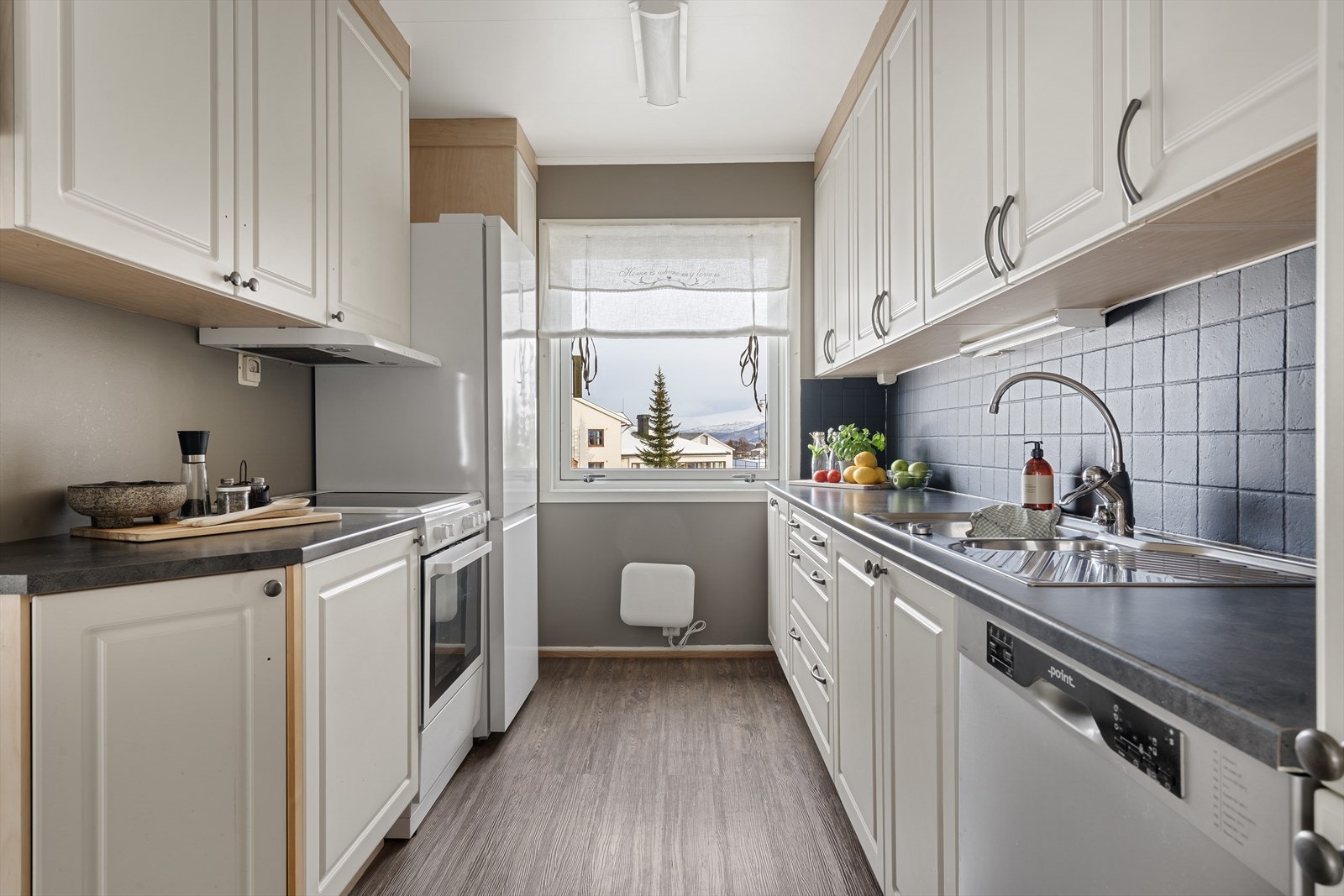 Hjemmet har et delvis separat kjøkken med inngang fra stue og gang. Galleribilde