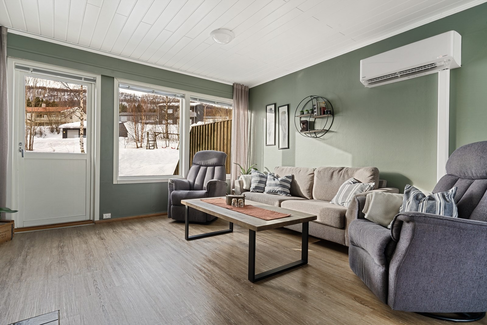 En romslig stue med store vindusflater som har godt med naturlig lysinnslipp. Galleribilde