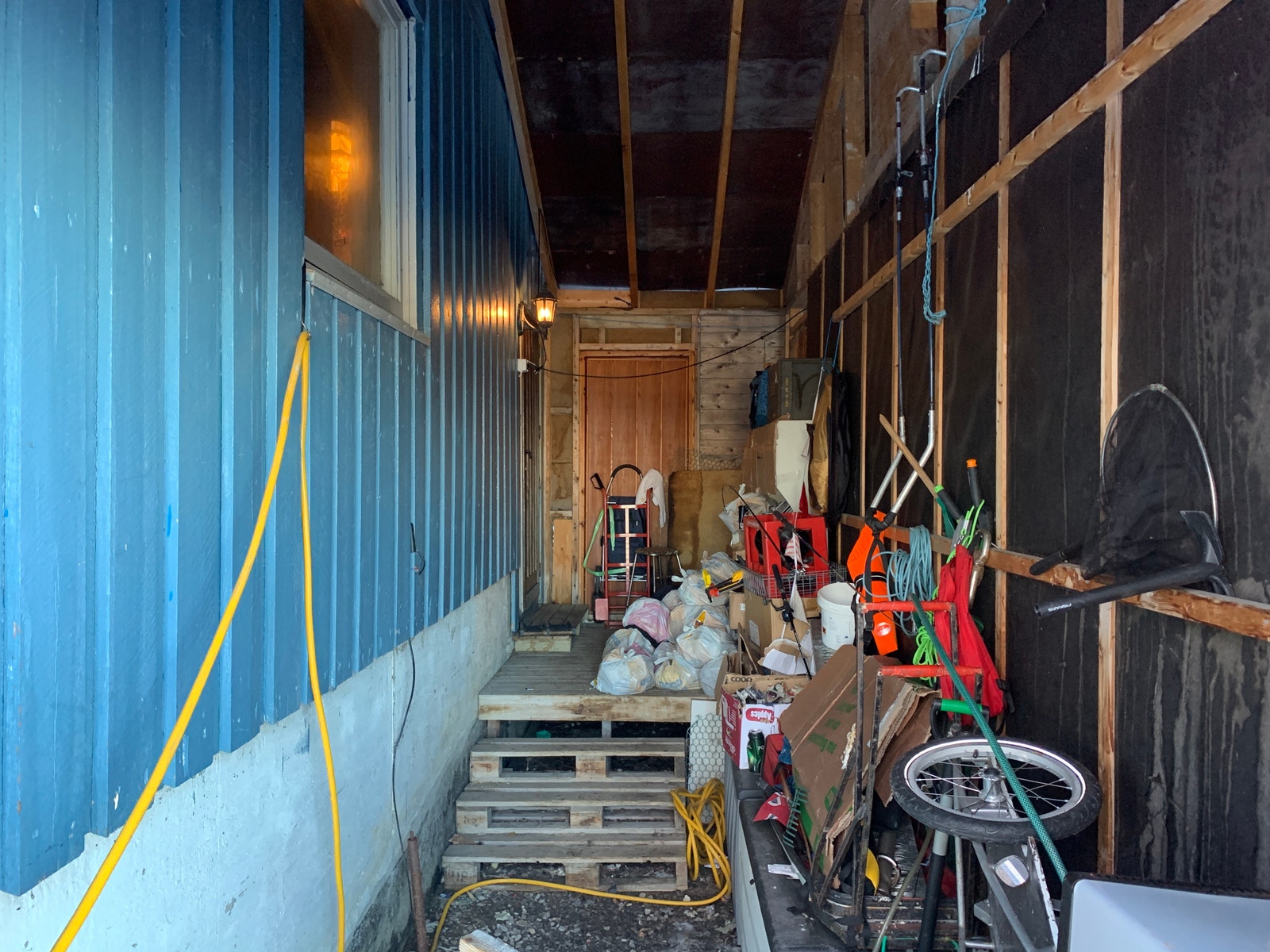Svalgang mellom bolig og garasje med god plass for oppbevaring skjermet for vær og vind. Galleribilde