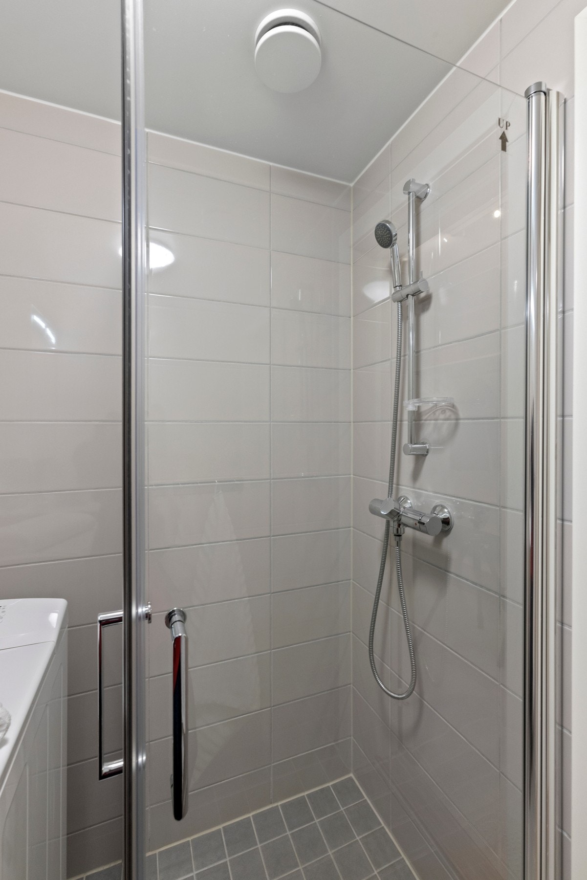 Rommet er utstyrt med servant med slette fronter, dusjhjørne med to svingbare glassdører og opplegg for vaskemaskin Galleribilde