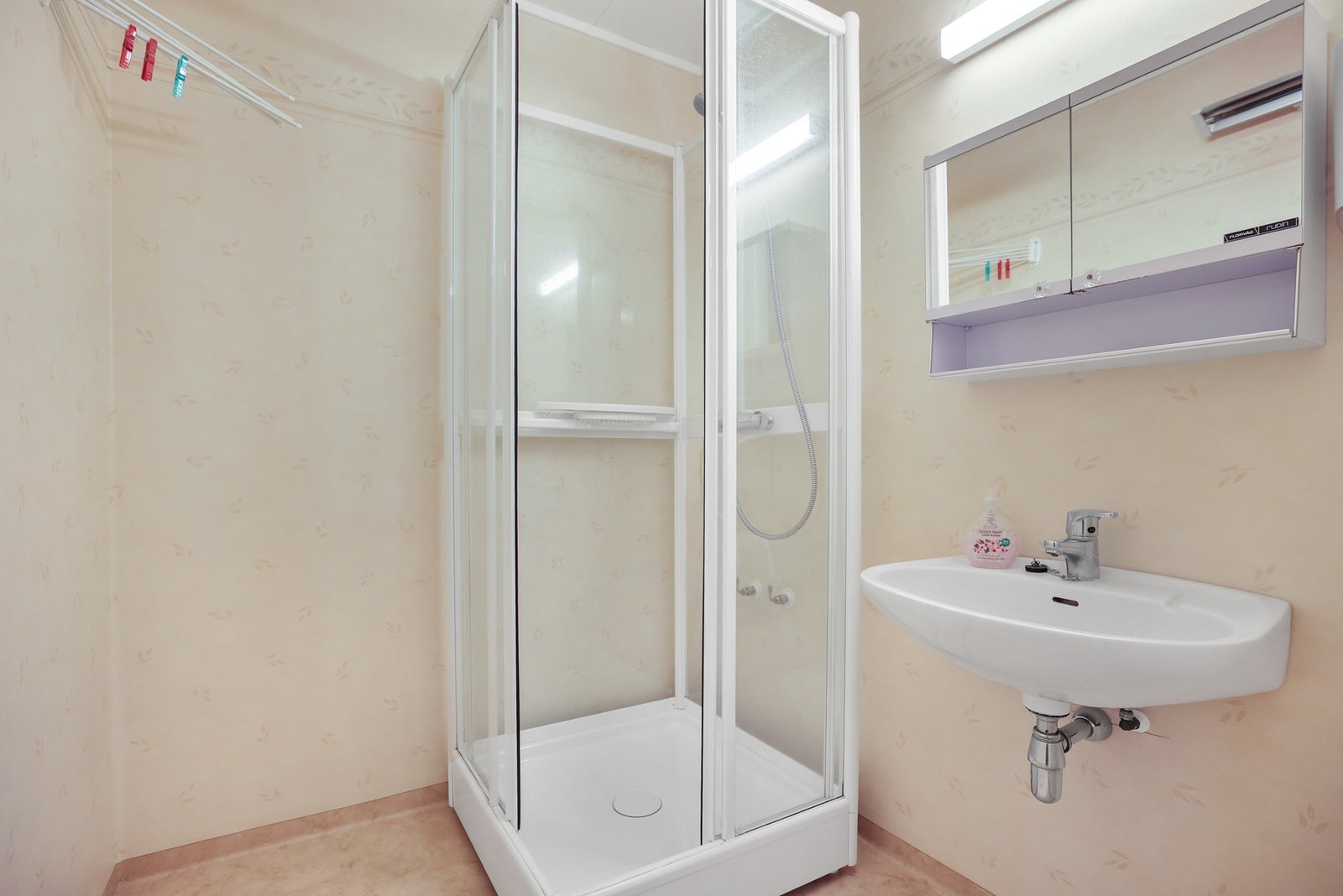 Badet inneholder vegghengt servant, speilskap med overlys og dusjkabinett. Galleribilde