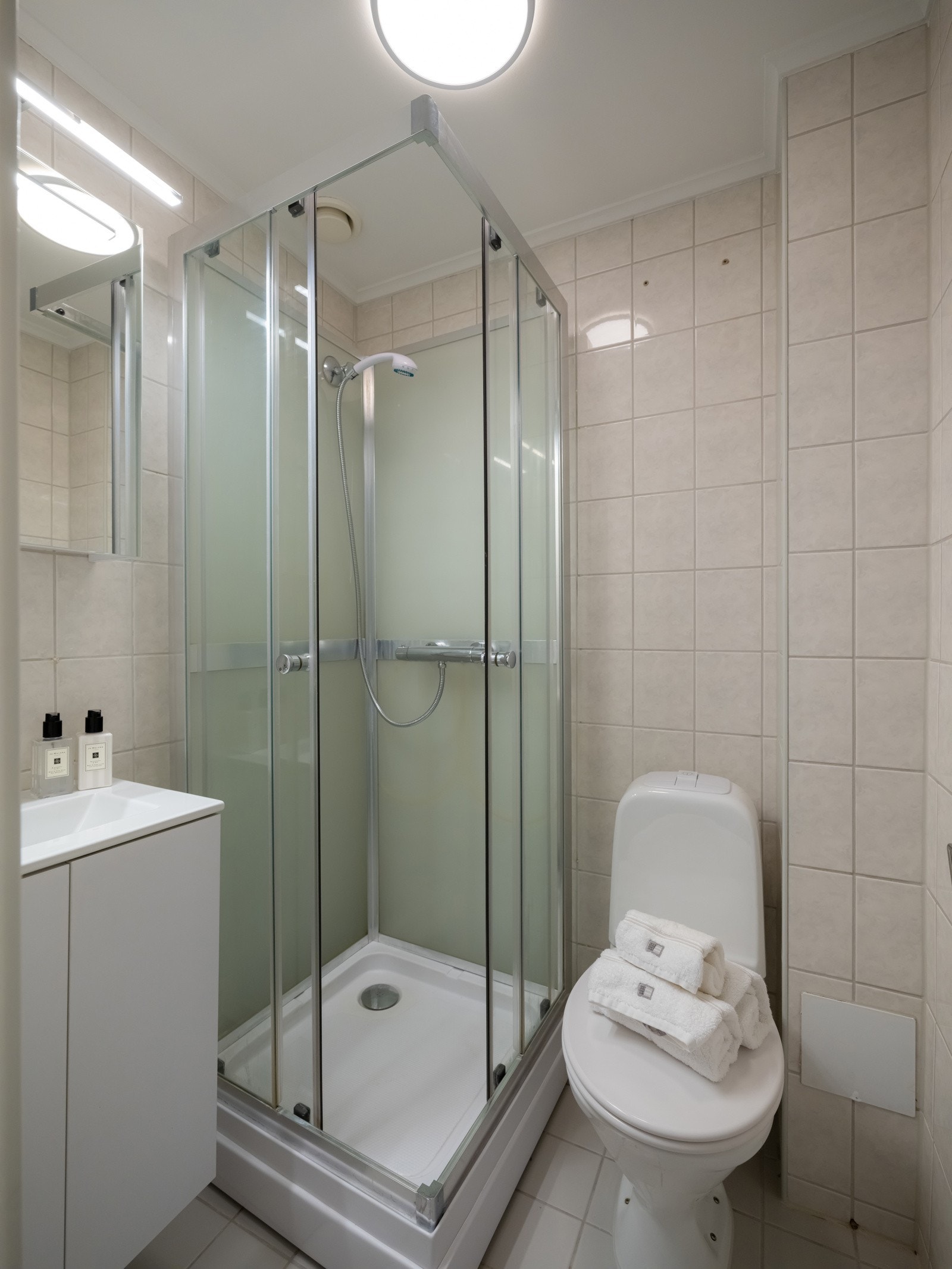 Leiligheten har et lyst og flislagt baderom med dusjkabinett. Det er varmekabler i gulvet. Galleribilde