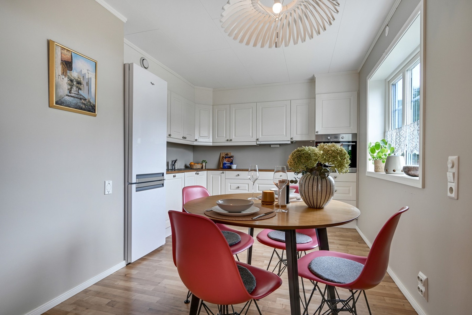 Kjøkkenet fremstår tidløst med lyse fronter og integrert komfyr og oppvaskmaskin. Kjøle/fryseskapet medfølger også Galleribilde