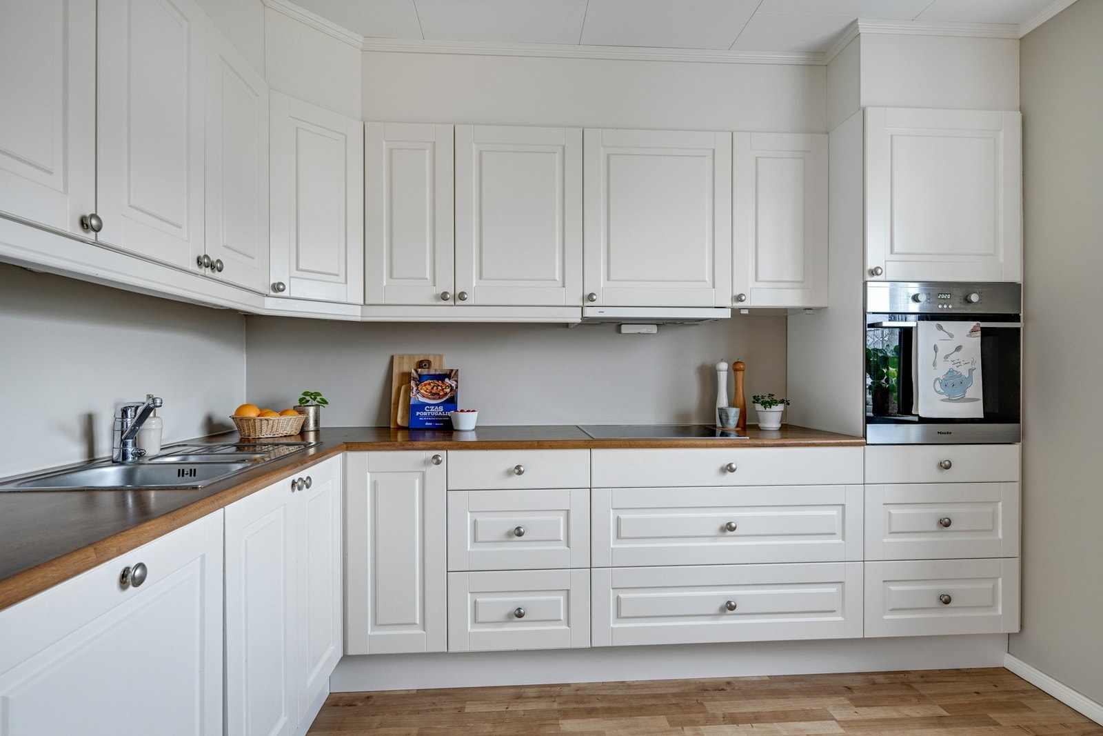 Delikate farger og en pen benkeplate av laminat. Det er ventilator med avtrekk ut Galleribilde