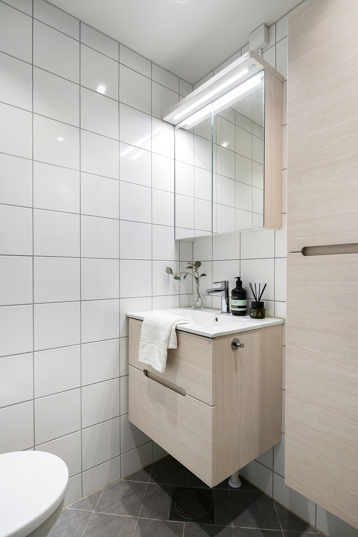 Veggmontert toalett samt servant med underskap og speilskap med belysning Galleribilde