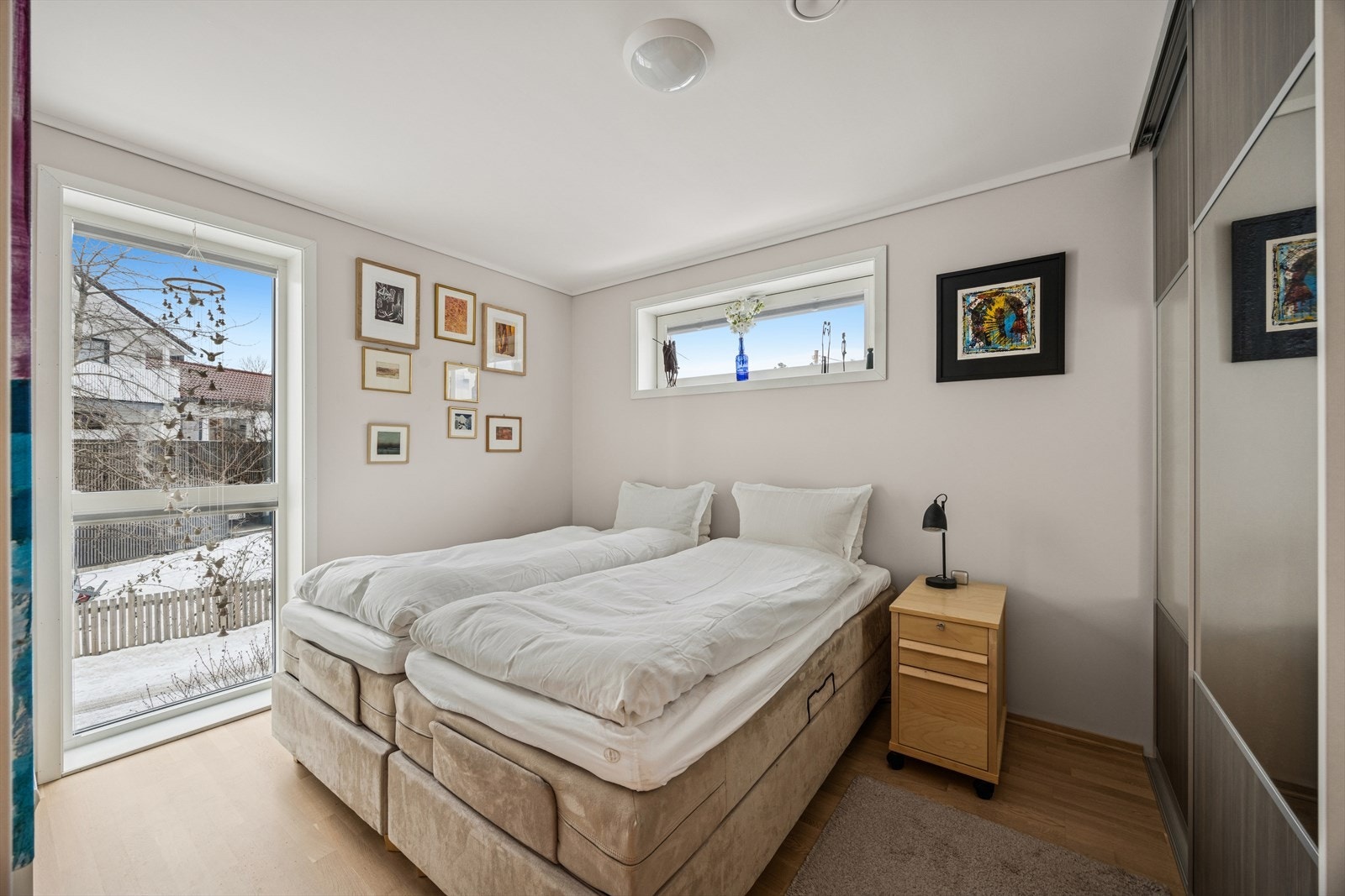 Romslig hovedsoverom med praktisk skyvedørsgarderobe, vinduer med lystette gardiner og tilknytning til bod som gir ekstra oppbevaringsmuligheter. Galleribilde