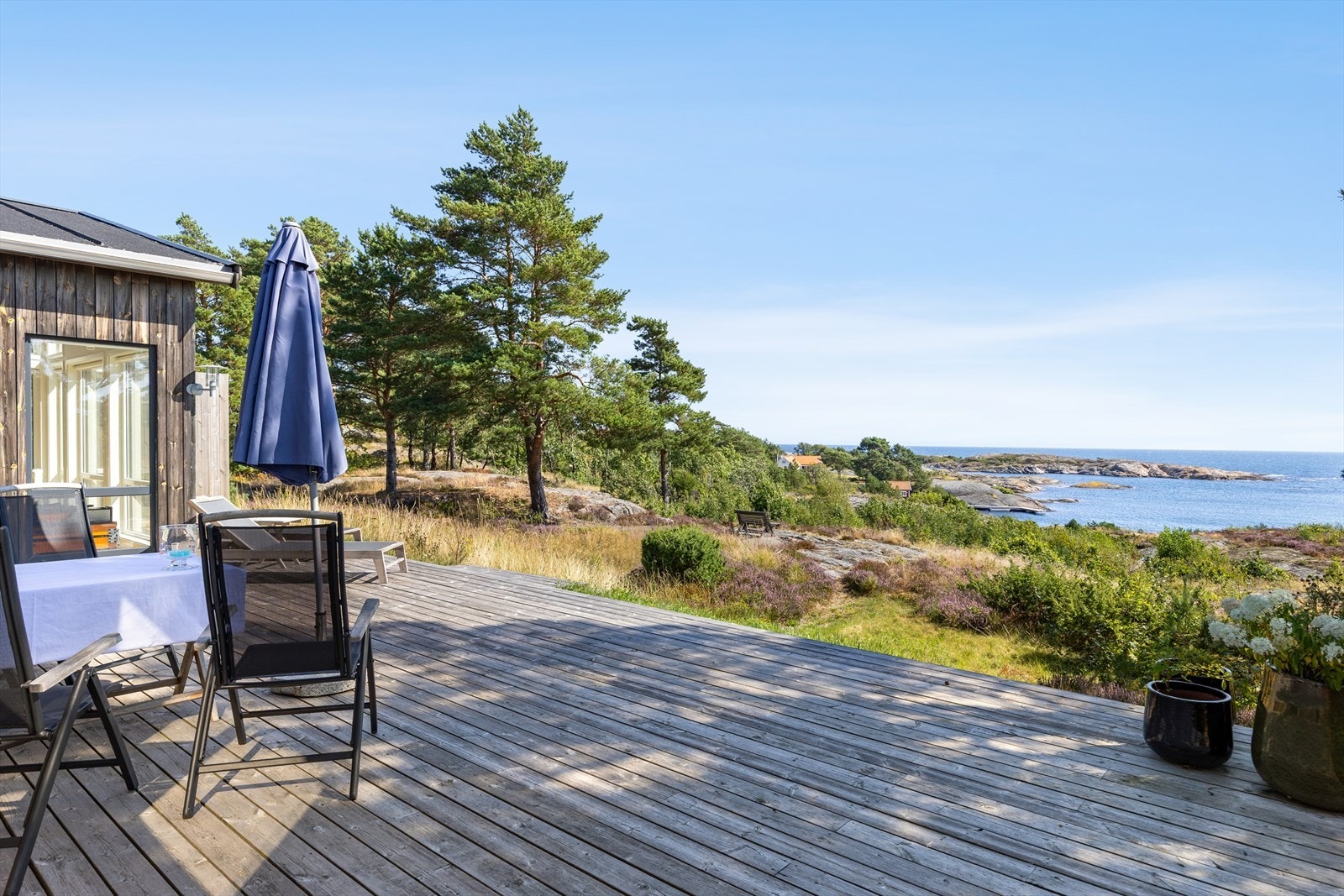Stor terrasse med flott utsikt mot sjø og åpent kystlandskap. Galleribilde
