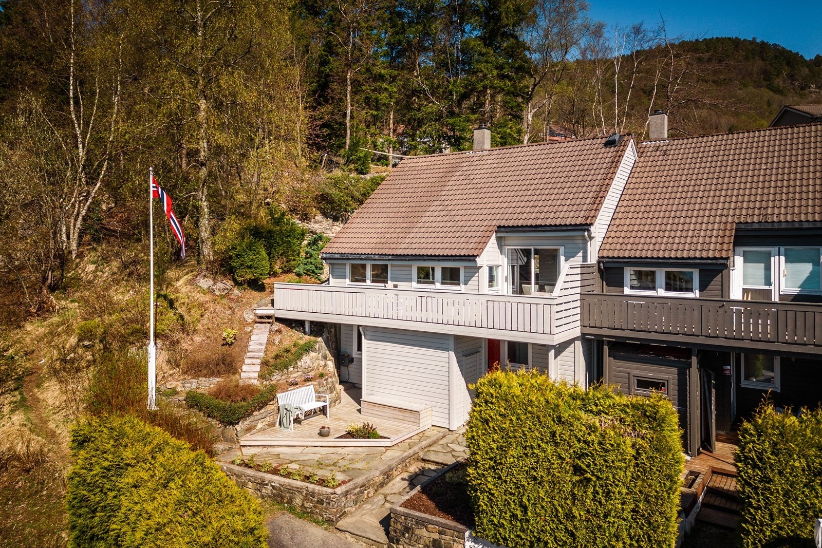 Rekkehuset fra 1985 ble tilbygget i 1992 og har en fint opparbeidet tomt med natursteinsmurer, terasser og pen beplantning. Galleribilde