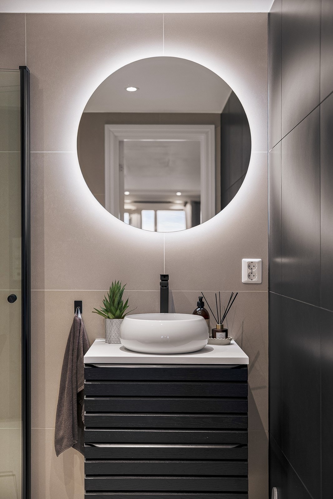 Badet har fasiliteter som stort og romslig dusjhjørne, veggfestet toalett og en nydelig servant. Galleribilde