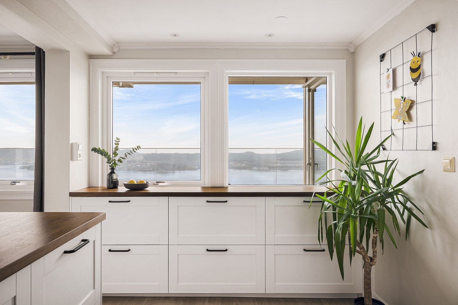 Her har man kjøkkenbenker i trefiner som står godt i stil med de tidsriktige fargene på kjøkkenet. Galleribilde