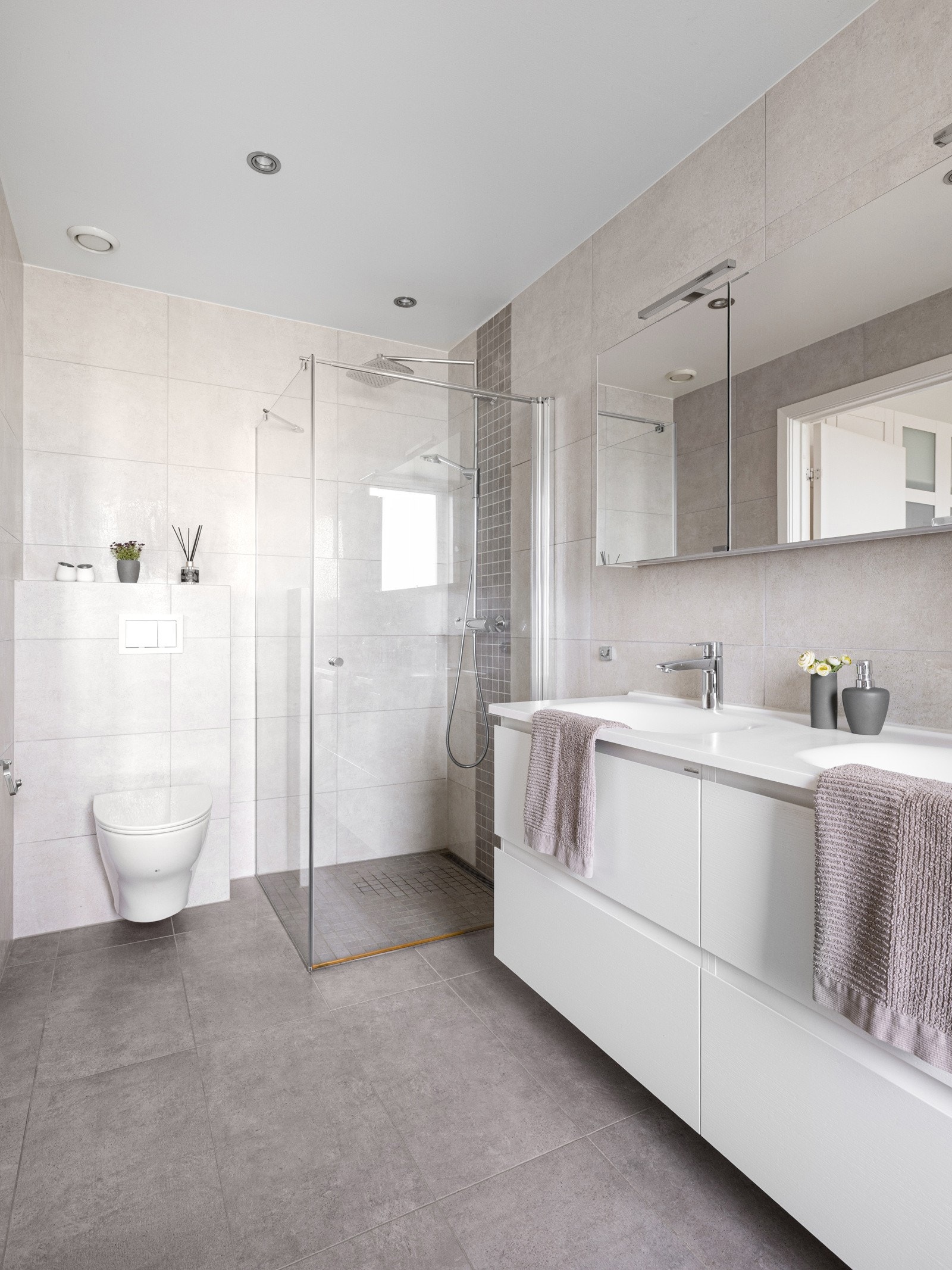 Innredningen består av en praktisk baderomsinnredning med dobbel servant, veggskap, vegghengt toalett, dusjhjørne og badekar. Galleribilde