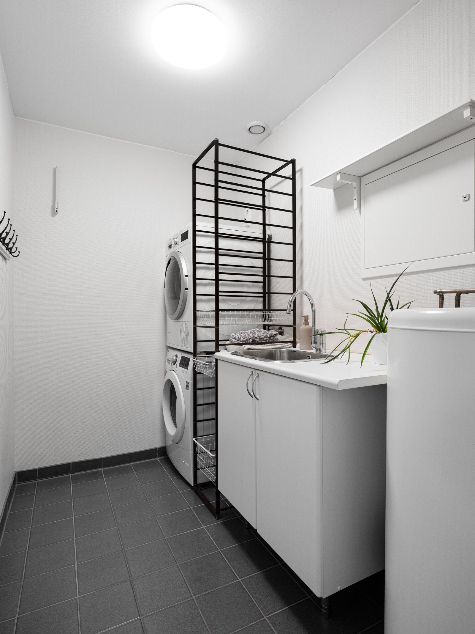 Boligen har et praktisk vaskerom utstyrt med innredning med servant, opplegg for vaskemaskin samt plass til tørketrommel. Galleribilde