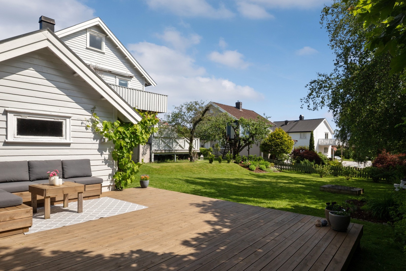 Bak garasjen er det etablert en stor, skjermet markterrasse med tredekke. Galleribilde