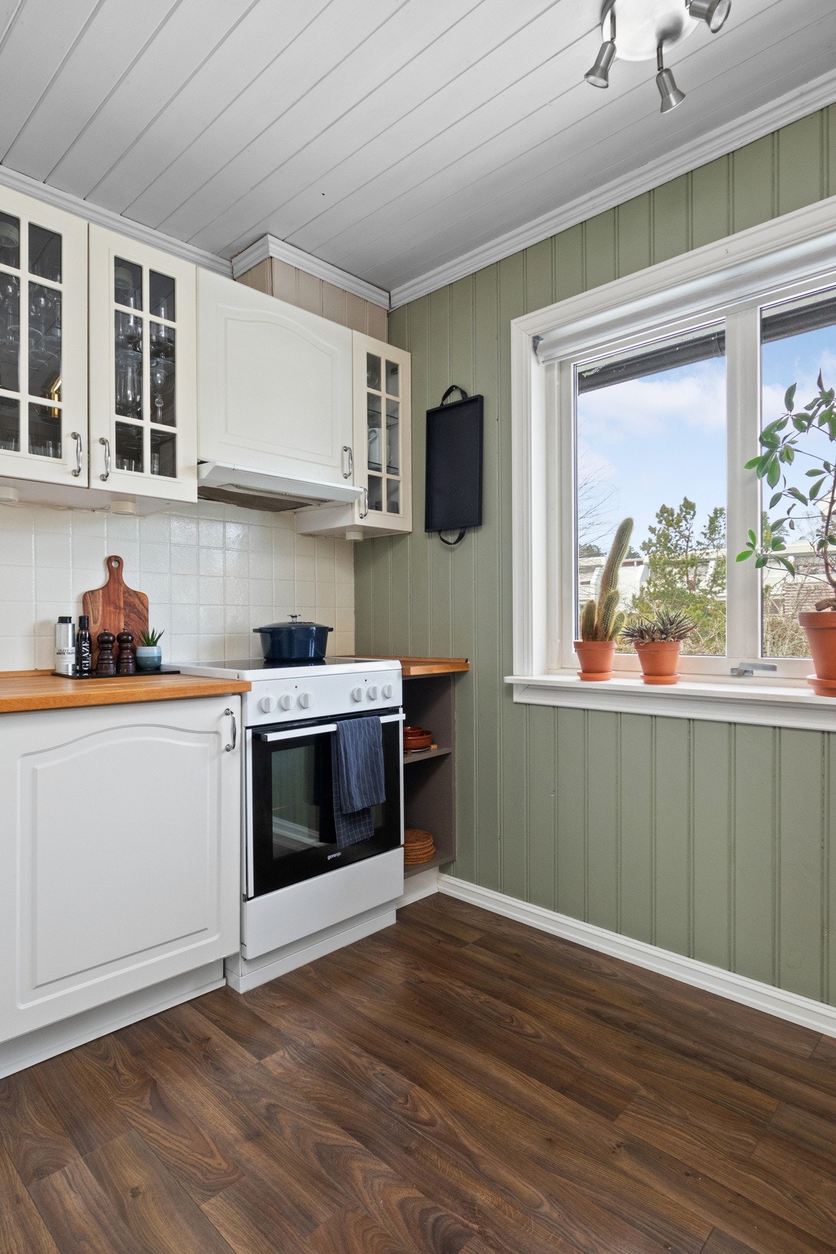 Innredningen har hvite, profilerte fronter og gyllen, solid heltrebenkeplate med nedfelt kum i stål. Galleribilde