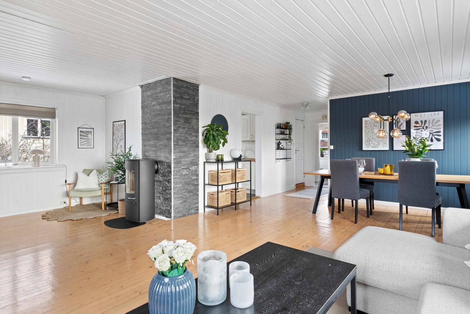 Veggene er malt opp i hvitt og mørkeblått, og stuen har lakkert, originalt heltregulv. Galleribilde